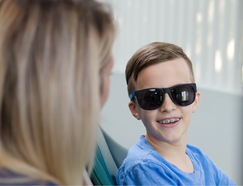young patient smiling and wearing sunglasses